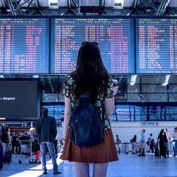 Girl at airport departures board in Manchester